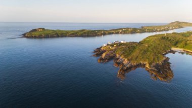 Nefes kesen bir hava görüntüsü çarpıcı ve sakin bir kıyı şeridini yakalar. Güzelce sergilenen kayalık çıkıntılar, yemyeşil ve canlı yeşilliklerle birlikte.