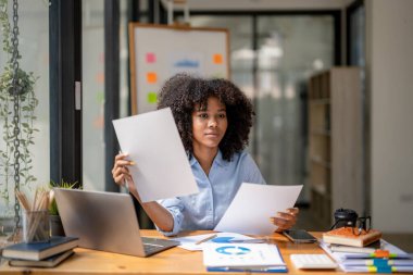 İş kadını çalışırken dikkati dağılmış, çalışırken başka şeyleri düşünmeden oturuyor.