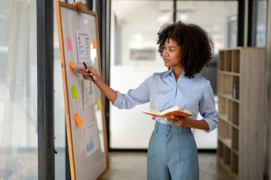 İş kadını strateji analizi planlıyor. Daha iyi planlama için pazarlama planını çalış.