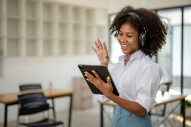 Kulaklıklı ve tabanlı Afrikalı Amerikalı kadınlar arkadaşlarıyla sosyal sohbetin keyfini çıkarırlar ya da ekip ile aile video görüşmesinin.