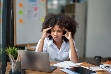 İş kadını iş yerinde stresli, yoğun çalışıyor stresli ve işinden dolayı başı dönüyor.