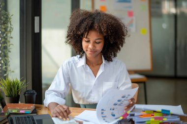 Siyahi kadın çok çalışıyor, mutlu mesut çalışıyor plan iyi gidiyor, ilginç hikaye, planı düşün, fikirler ileri sür, durumu analiz et.
