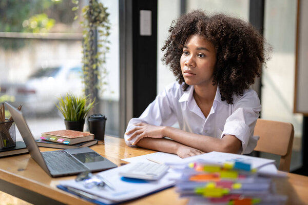 business woman sitting absent-minded at a table in office.