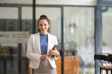 Ofiste dijital tablet tutan zeki bir iş kadını..