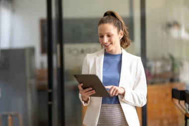 Akıllı iş kadını ofiste dijital tablet kullanıyor..