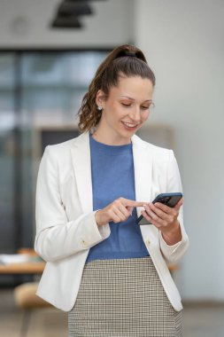 Akıllı iş kadını ofisteki telefonu kullanıyor..