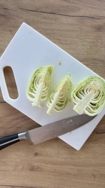 Beyaz tahtada taze beyaz lahana, yarım kafa.