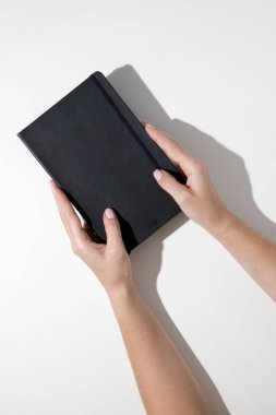 Ev ofisinin masası düzdü. Beyaz arka planda siyah defterleri olan çalışma alanı. Düz yerde, üst tarafta. Kadın ofis masası..