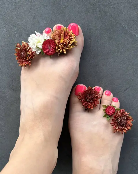 Perfect pedicure female legs in spa with flowers