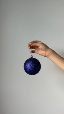 El ve kırmızı top ile Noel konsepti - Noel ağacı oyuncağı. Gri arkaplanda izole.