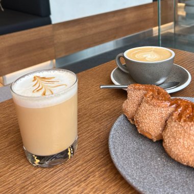 Kahveci kafede bir fincan kahve, tahta tahtada bir parça kek.