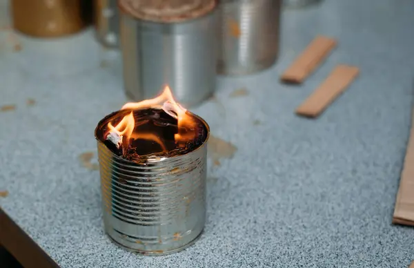 A trench candle in the form of a canister is burning in the room, in which cardboard filled with wax or paraffin is placed. Candles are made by Ukrainian volunteers for soldiers serving on the front lines.