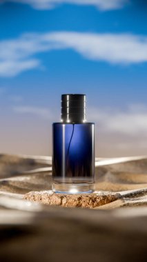 Parlak bir gökyüzünün altında çöl kumunun üzerinde duran koyu mavi bir desenli lüks parfüm şişesinin zarif 3D görüntüsü gizemi, zarafeti ve karmaşıklığı simgeliyor..