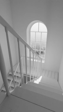 Üç boyutlu, kemerli tuğla duvarlı, geniş pencereli ve ahşap merdivenli eski bir oda. Atmosferik ışık çarpıcı bir endüstriyel klasik mimari iç mekan yaratıyor..