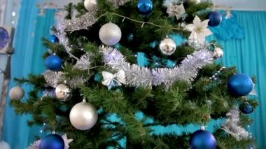 Noel tatili. Noel ağacı olan güzel dekore edilmiş bir ev. Süslü bir Noel ağacında asılı renkli oyuncaklar ve toplar. Tam HD.