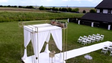 Düğün hazırlıkları. Restoranın dışında düğün töreni. Gelin ve misafirler için sandalyeler ve beyaz geçitler. 4 bin. Drone ateş ediyor. Havadan.