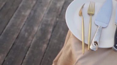 İki yaldızlı çatal ve pasta için bir bıçak düğün pastasının etrafındaki beyaz tabakta. Doğum günü, düğün.