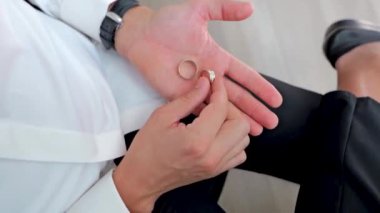 Adam pencerenin etrafında bir sandalyeye oturur ve elinde iki yüzük tutar. Yukarıdan görüntüle, 360 derece döndürülmüş video.