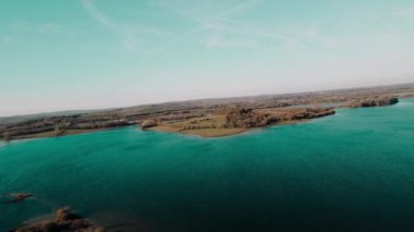 Sonbahar manzarası. Ağaçların ilk yaprakları. Sonbaharda ekim ayında. Rutland Gölü üzerinde uçan 4k hava manzaralı su, İngiltere