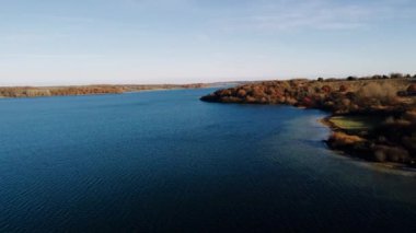 Sonbahar manzarası. Ağaçların ilk yaprakları. Sonbaharda ekim ayında. Rutland Gölü üzerinde uçan 4k hava manzaralı su, İngiltere
