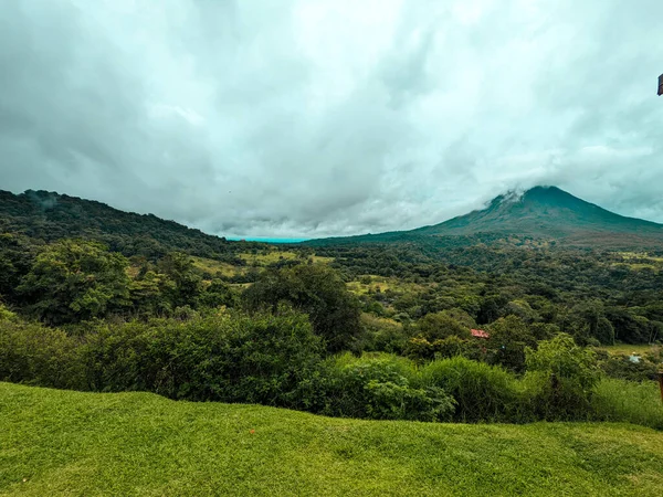 Arenal Volkanı, La Fortuna, Kosta Rika. La Fortuna, Kosta Rika 'daki zirveyi çevreleyen bulutlu Arenal Volkanı. Yeşil yapraklar ve tropikal ormanlar.