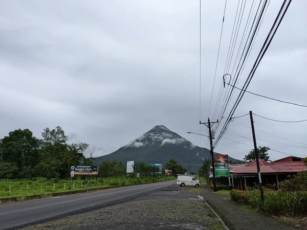 Arenal Volkanı, La Fortuna, Kosta Rika. La Fortuna, Kosta Rika 'daki zirveyi çevreleyen bulutlu Arenal Volkanı. Yeşil yapraklar ve tropikal ormanlar.