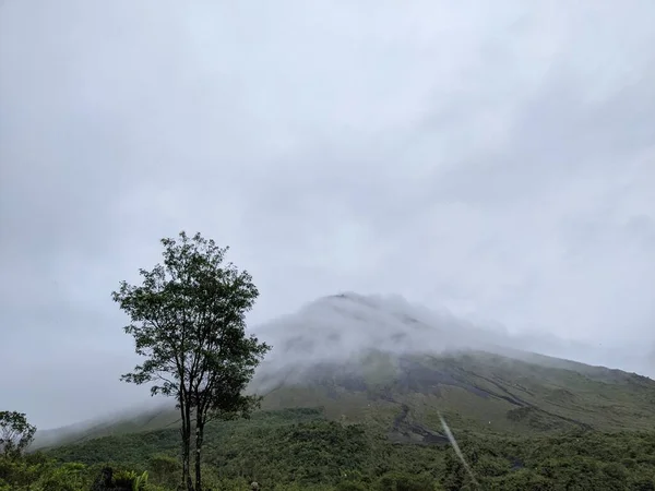 Arenal Volkanı, La Fortuna, Kosta Rika. La Fortuna, Kosta Rika 'daki zirveyi çevreleyen bulutlu Arenal Volkanı. Yeşil yapraklar ve tropikal ormanlar.