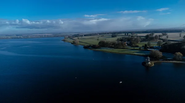 .Rutland İngiltere 'deki Rutland Su rezervuarının havadan görüntüsü. Mavi suları ve Normanton Kilisesi yerinde ve İngiltere' de kışın limandan denize açılan yatları var..