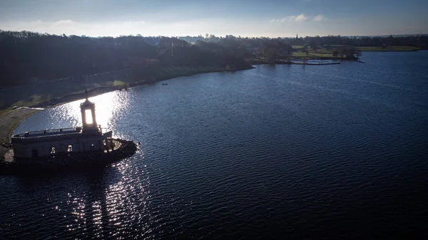 İngiltere 'de Rutland Su Gölü rezervuarındaki Normanton Kilisesi Manastırı' nın aşağı tarafındaki hava manzarası gün batımında açık gökyüzü olan soğuk ve buzlu havalarda.. 