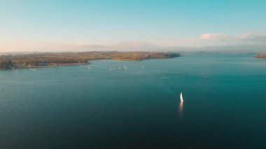 Rutland İngiltere 'deki Rutland Su rezervuarının 4k yukarıdaki hava manzarası. Mavi suları ve Normanton Kilisesi manzaralı ve İngiltere' de kışın limandan ayrılan yatları var.