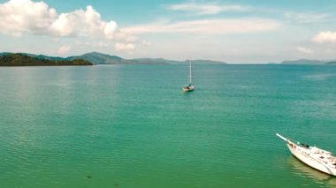 Palawan, Filipinler 'deki Port Barton Limanı üzerindeki hava manzarası güneşli bir sabahta. Mavi denizler ve gökyüzü. Yat körfeze yanaştı..