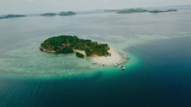 Coron Adası 'nın 4k hava manzarası ve Filipinler' deki Coron Adası 'nın kıyısından geçen bir ada. Güzel tropik plajlar, mangrovlar, turkuaz sular, hindistan cevizi kaplı plajlar..