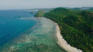 Filipinler 'deki Calauit Ulusal Parkı Coron Adası etrafındaki küçük adaların ve plajların 4k görüntüsü. Kristal berrak turkuaz mavi sular, palmiye ağaçları beyaz kumlu plajlar ve görünür mercan resifleri.. 