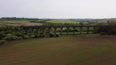 İngiltere 'de parlak ama puslu bir günde Twyford viyadük etrafında uçan hava manzaralı 4k. Sinematik.