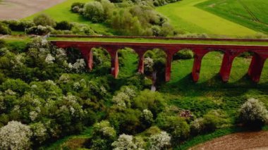 İngiltere 'de parlak ama puslu bir günde Twyford viyadük etrafında uçan hava manzaralı 4k. Sinematik.