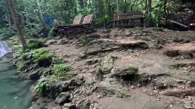 Point of view of huge tropical waterfall and lagoon, clear blue waters and verdant lush green jungle foliage in the Philippines Asia 