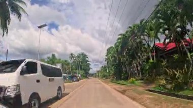 Point of view driving riding a motorbike scooter along tropical roads in the Philippines, Asia. lush green jungle and bright sunshine, travel content, scenic tourism, vacation holiday 