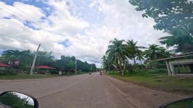 Point of view driving riding a motorbike scooter along tropical roads in the Philippines, Asia. lush green jungle and bright sunshine, travel content, scenic tourism, vacation holiday 