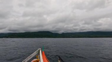 Point of view riding on Bangka Boat, water ferry, fishing vessel in Asia, Philippines, tropical landscapes and clear blue waters, vacation, backpacking, holiday tourism