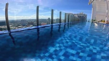 Point of view from top of hotel roof top pool in Manila, Philippines, Asia, holiday and vacation travelling, blue skies and blue pool water