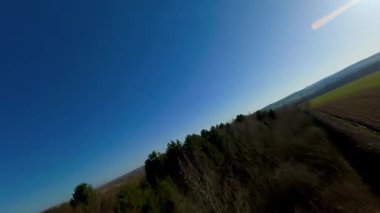 FPV aerial drone view close flying over rural farmland fields and livestock in England cold sunny Spring day, grass pastures 