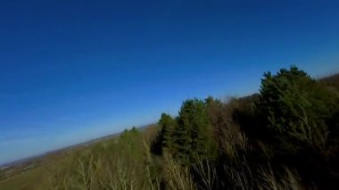 FPV aerial drone view close flying over rural farmland fields and livestock in England cold sunny Spring day, grass pastures 