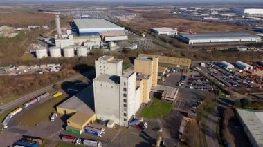 Aerial drone view of power plant, station with chimney stacks, gas burning chamber, fuel storage silos and industrial buildings, Corby England UK