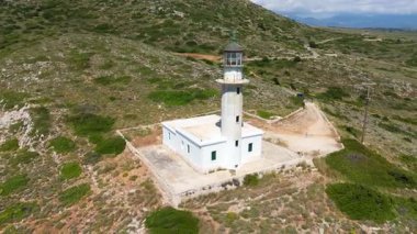 Yunanistan 'ın Kefalonia kentindeki sahil şeridindeki beyaz deniz fenerinin hava manzarası. 