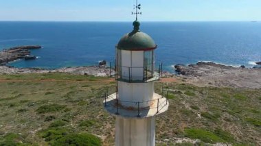 Yunanistan 'ın Kefalonia kentindeki sahil şeridindeki beyaz deniz fenerinin hava manzarası. 