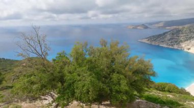 High footage of Myrtos beach and Ionian sea Kefalonia: vibrant blue water, white pebble arc, dramatic mountain cliffs