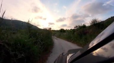 Akdeniz 'de gün batımında gün batımında gün batımında Yunanistan' da Akdeniz yollarında araba süren bakış açısı, aksiyon tarzı düşük atışlar ve tatil turizmi sırt çantalı tatil şeritleri  