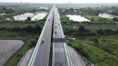 İnsansız hava aracı görüntüleri demiryolu köprüsünde trafiği gösteriyor. Şehri ve sabah sisini gösteriyor..