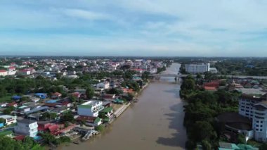Su boyunca kırmızı çamur ve şehir manzaralı nehir yolu videosu.