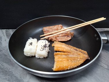 Tavada kızarmış domuz ve kızarmış balık ile yemek fotoğrafı.